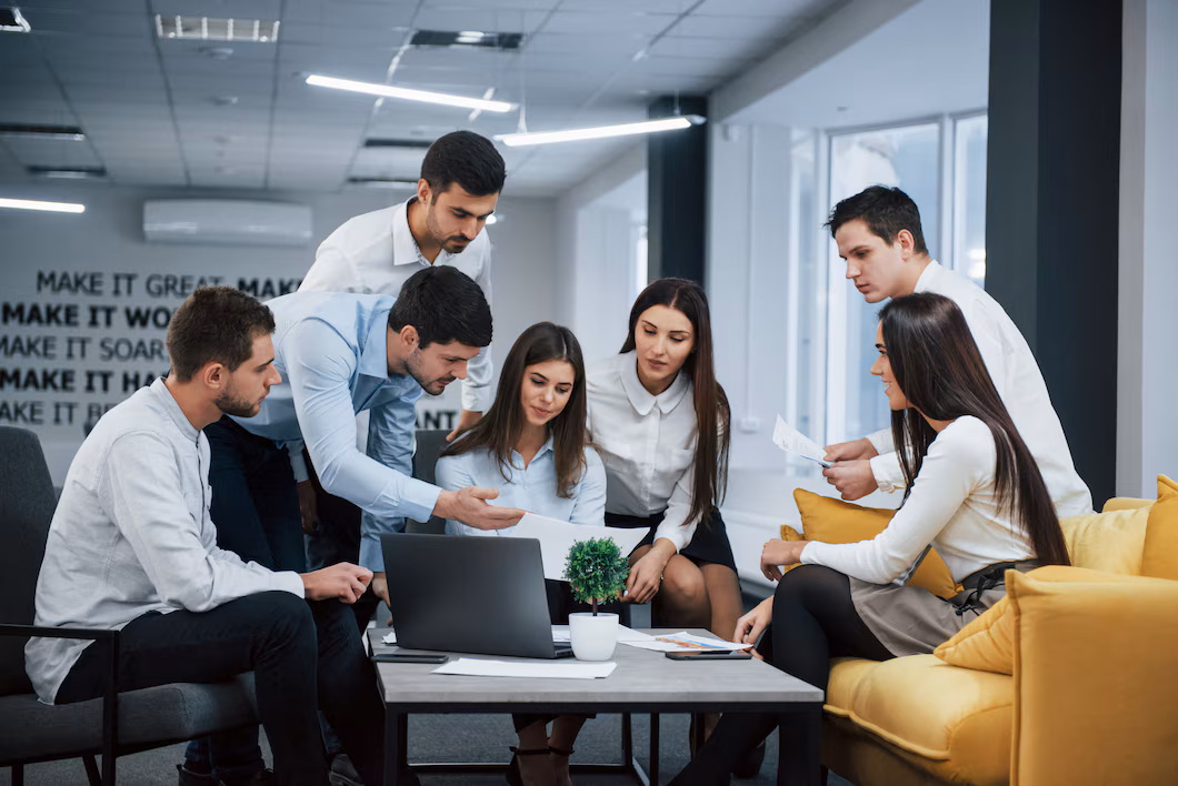 guy-shows-document-girl-group-young-freelancers-office-have-conversation-working_146671-13569